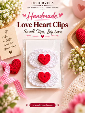 Decorvela handmade love heart clips in a clear plastic sleeve, surrounded by pink and white flowers, a pink gingham ribbon, and other crocheted red heart accessories on a soft pink background.