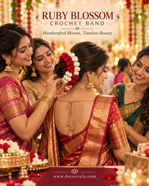 A group of women in traditional Indian attire gather around a bride or bridesmaid, with one woman adjusting a floral hair accessory. The scene is decorated with warm string lights and red and gold fabrics.